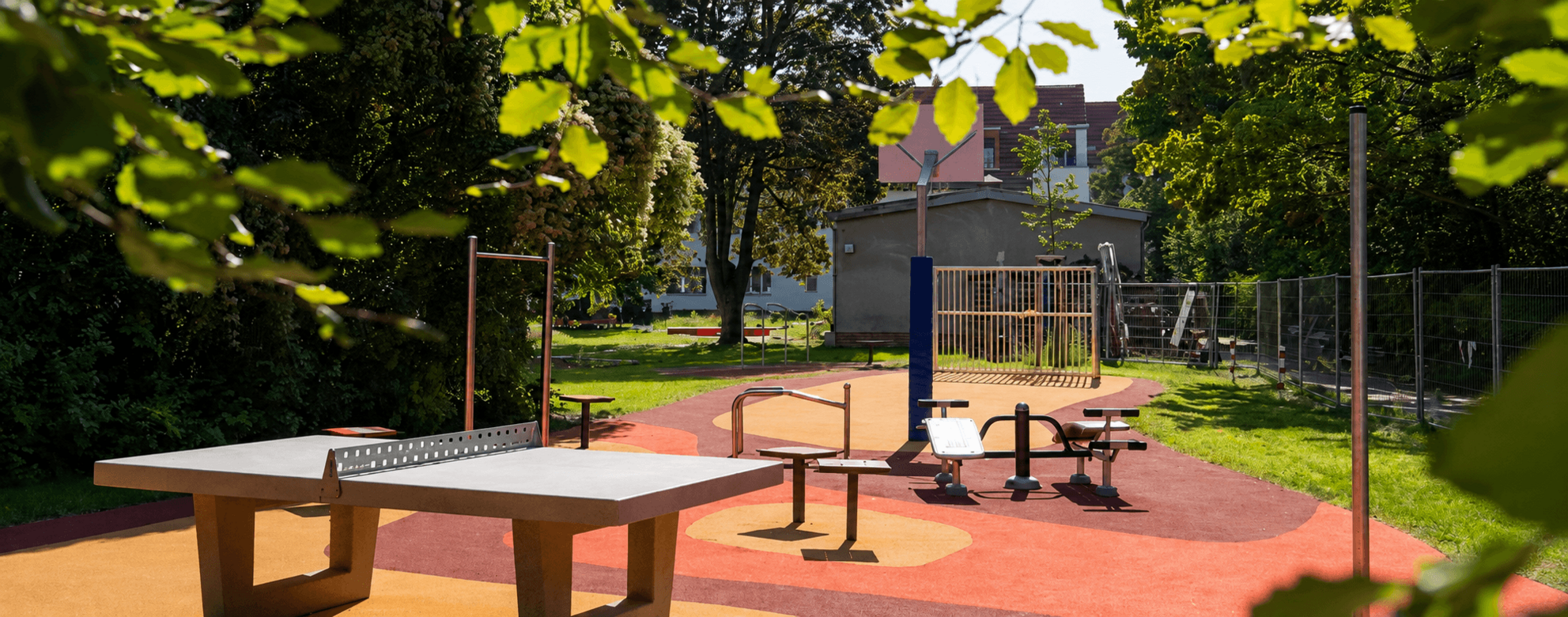 Accessible REGUPOL Play Area in Berlin-Steglitz-Zehlendorf Accessible playground in Berlin-Steglitz-Zehlendorf with REGUPOL impact-absorbing safety surfacing, fitness equipment, table tennis facilities, and an inclusive play and recreation area for children, families, and adults.