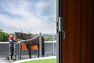 Outdoor horse wash bay with slip-resistant REGUPOL equestrian flooring – weather-resistant, shock-absorbing flooring for safe grooming and washing areas at equestrian facilities