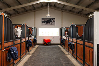 Stable aisle with horse stalls and durable REGUPOL equestrian flooring – slip-resistant, shock-absorbing flooring for safe and horse-friendly stable environments