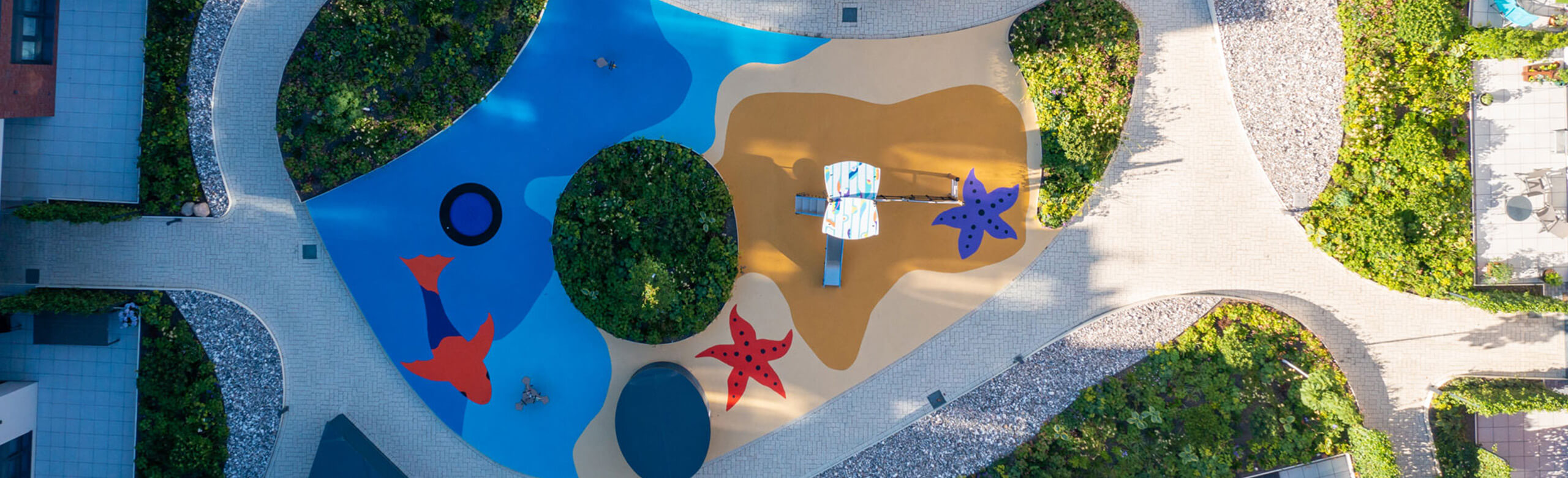 Playground with a seamless safety flooring in beach design (fish, starfish, sand, water) from REGUPOL