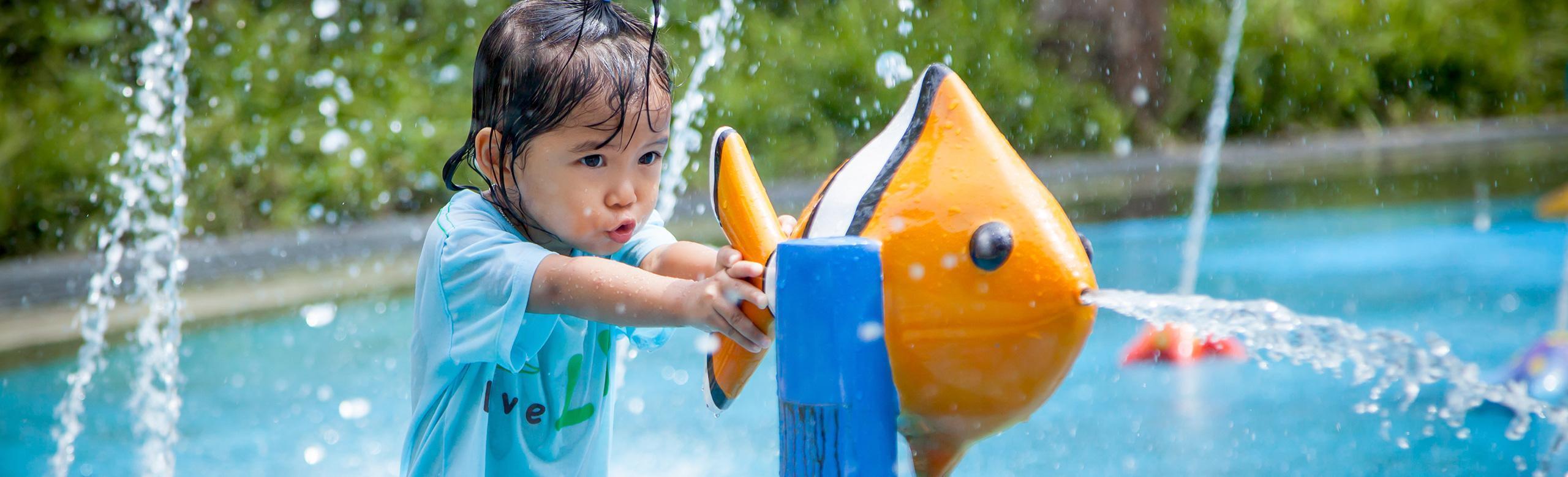 Child playing on water playground with REGUPOL playfix safety flooring
