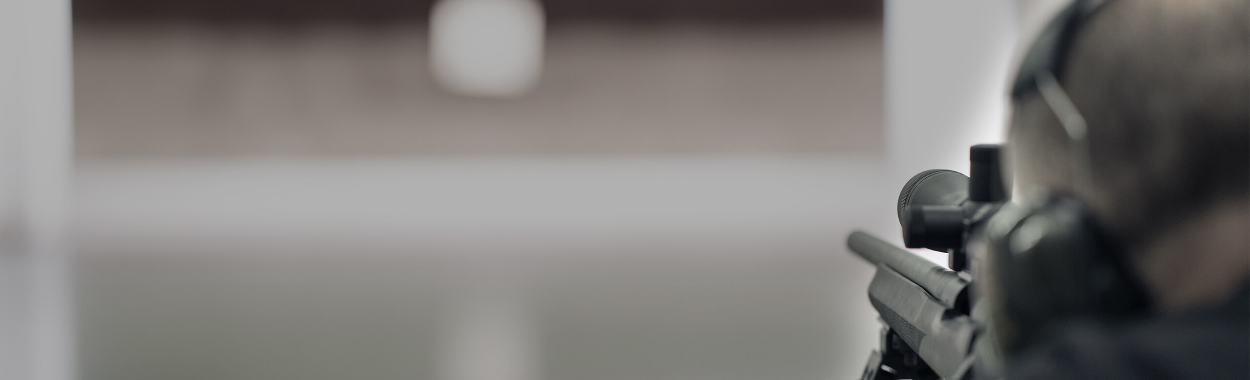 Shooter in a shooting range Shooter with a gun and helmet training in a shooting range